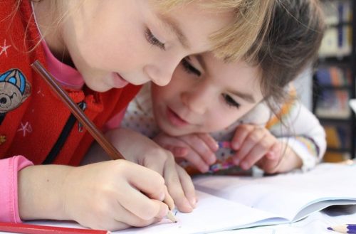 Two children collaborating on a piece of writing